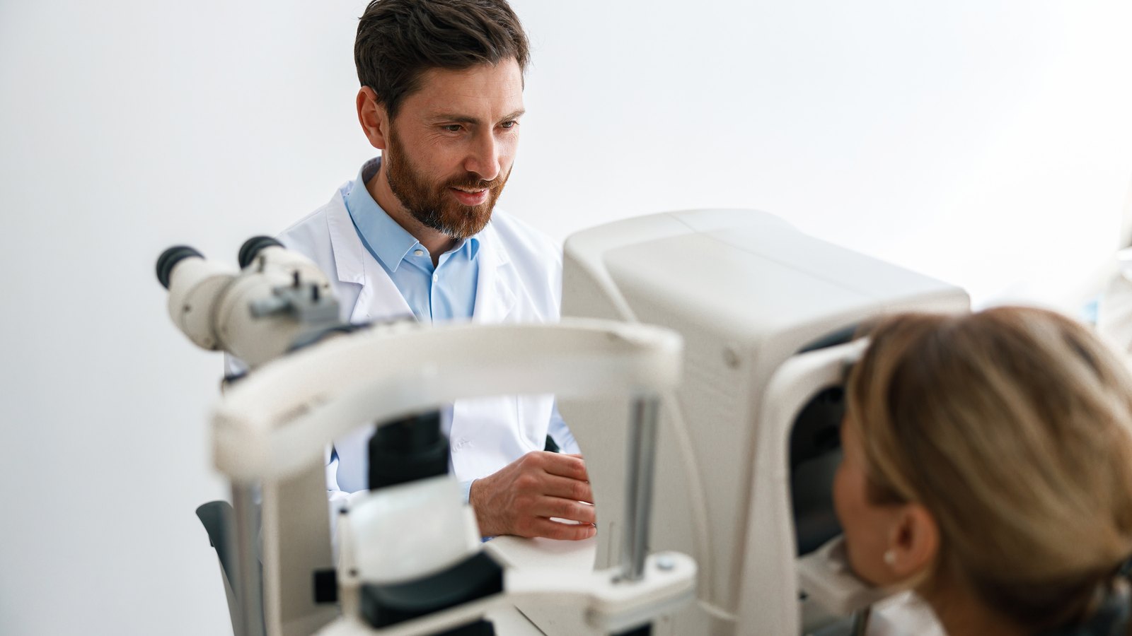 Ophthalmologist examining a patient at the slit lamp during a glaucoma eye exam